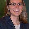 Jorri (Heil) Smith, wearing glasses and a blazer, smiles.
